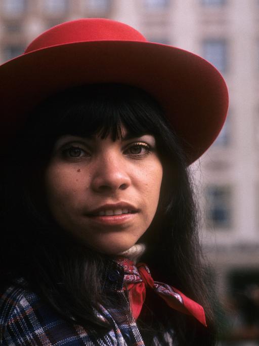 Die Sängerin und Schauspielerin Olivia Molina mit rotem Hut im Porträt