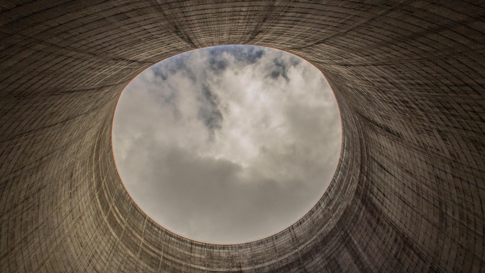 Blick aus einem Kühlturm für ein Kernkraftwerk, welches nicht fertig gestellt wurde. Oben zeigt sich der Himmel im kreisrunden Ausschnitt. Blick aus einem Kühlturm für ein Kernkraftwerk, welches nicht fertig gestellt wurde. Oben zeigt sich der Himmel im kreisrunden Ausschnitt.