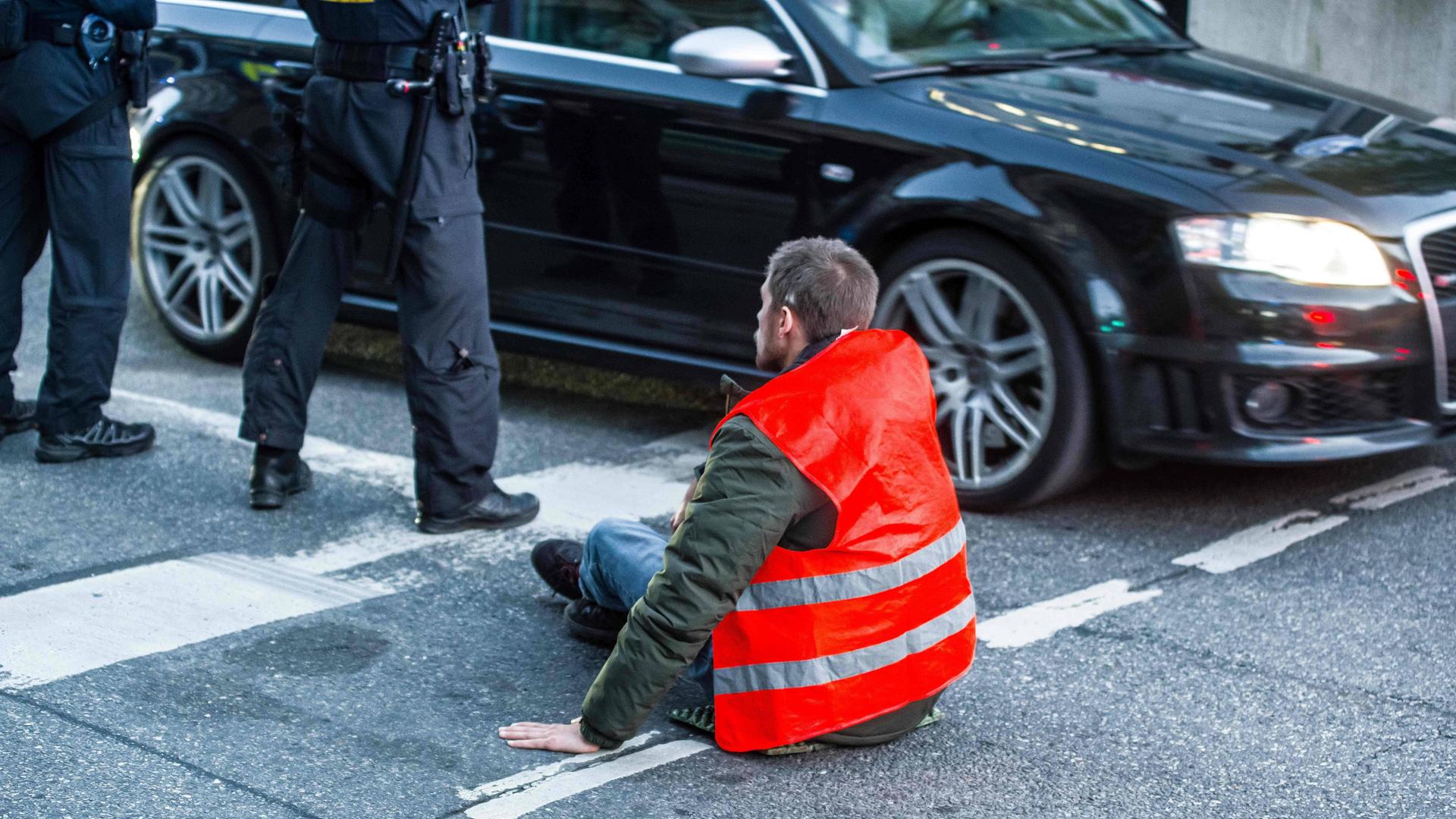 Ein Klima-Aktivist von der "Letzten Generation" hat sich in München auf einer Straße festgeklebt. Ein Klima-Aktivist von der "Letzten Generation" hat sich in München auf einer Straße festgeklebt.