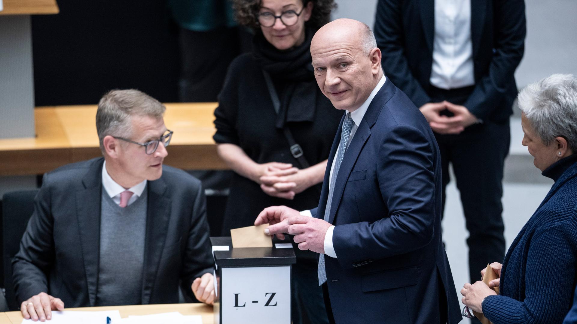 Kai Wegner (CDU) wirft seinen Stimmzettel in eine Wahlurne.
