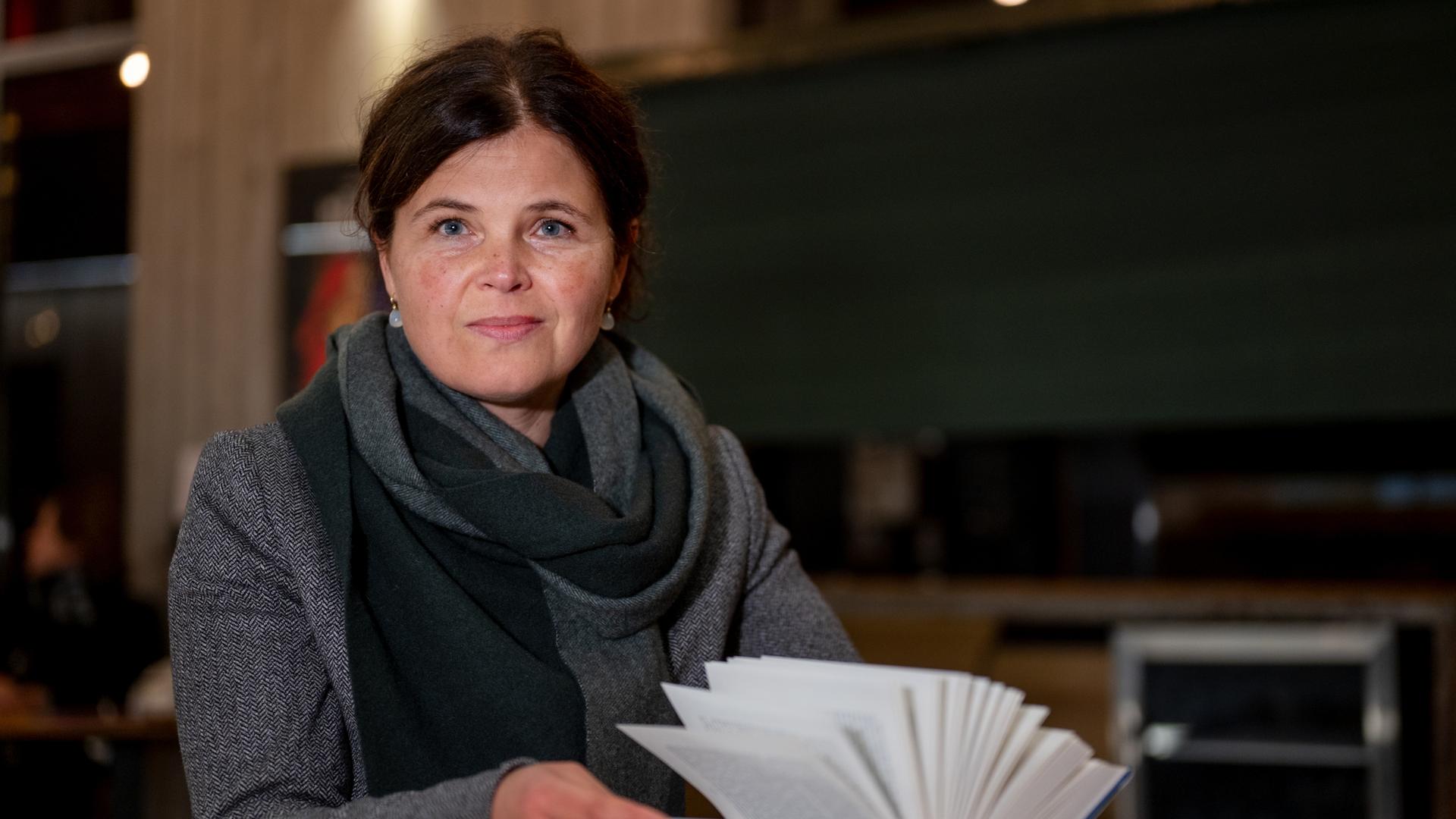 Schriftstellerin Julia Franck sitzt an einem Tisch mit einem aufgeschlagenen Schriftstellerin Julia Franck sitzt an einem Tisch mit einem aufgeschlagenen
