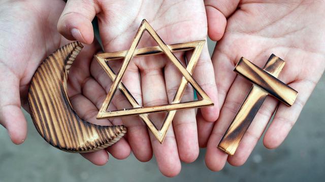 Aus Holz gefertigte religiöse Symbole des Islam (Halbmond), Judentums (Davidstern) und Christentums (Kreuz)  