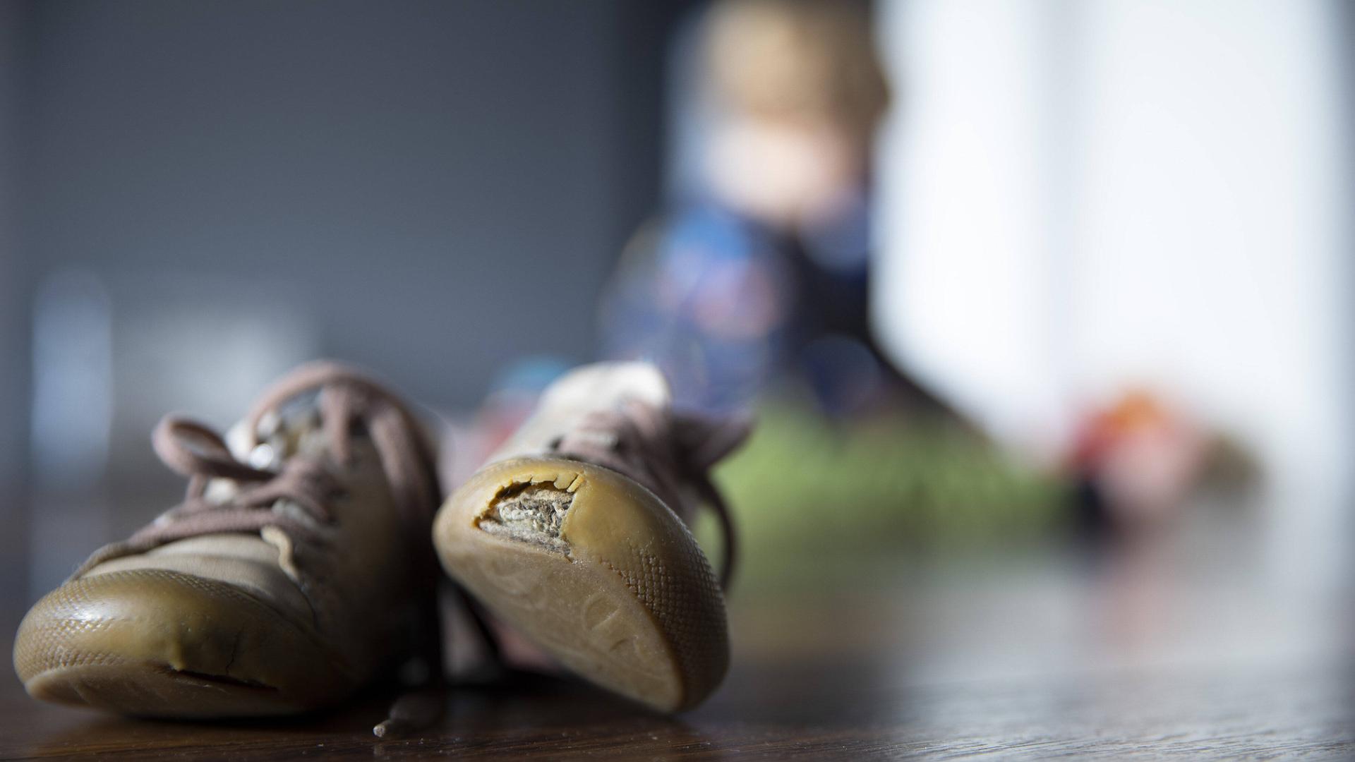 Einer von zwei Kinderschuhen im Bild hat ein Loch im vorderen Bereich. Einer von zwei Kinderschuhen im Bild hat ein Loch im vorderen Bereich.