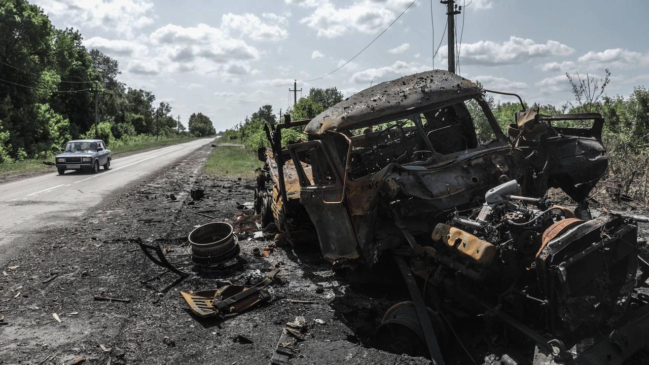 Russland, Belgorod, Region Kozinka: Ein zerstörtes Fahrzeug steht am einer Straße. 