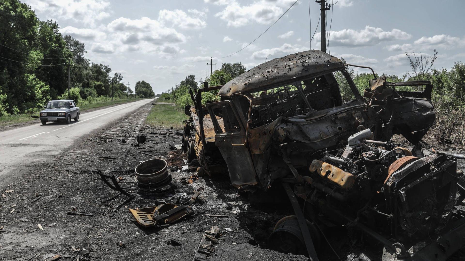 Russland, Belgorod, Region Kozinka: Ein zerstörtes Fahrzeug steht am einer Straße. 