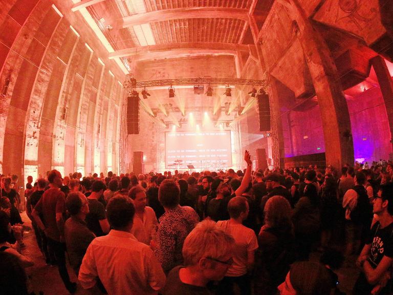 Der Club Berghain in Kreuzberg mit Publikum vor der beleuchteten Bühne