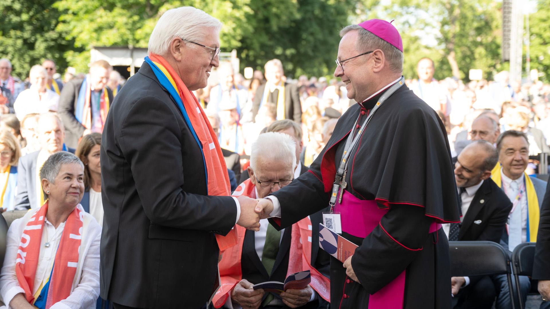 Bundespräsident Steinmeier und der Vorsitzende von der Deutschen Bischofs-Konferenz, Bätzing, geben sich die Hand.