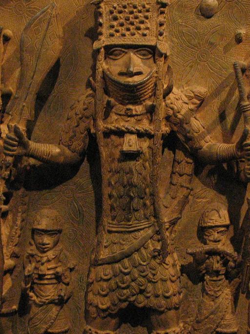 Auf einem Bronzerelief aus Benin sind Krieger mit Speeren, Rüstung und Helmen abgebildet. 