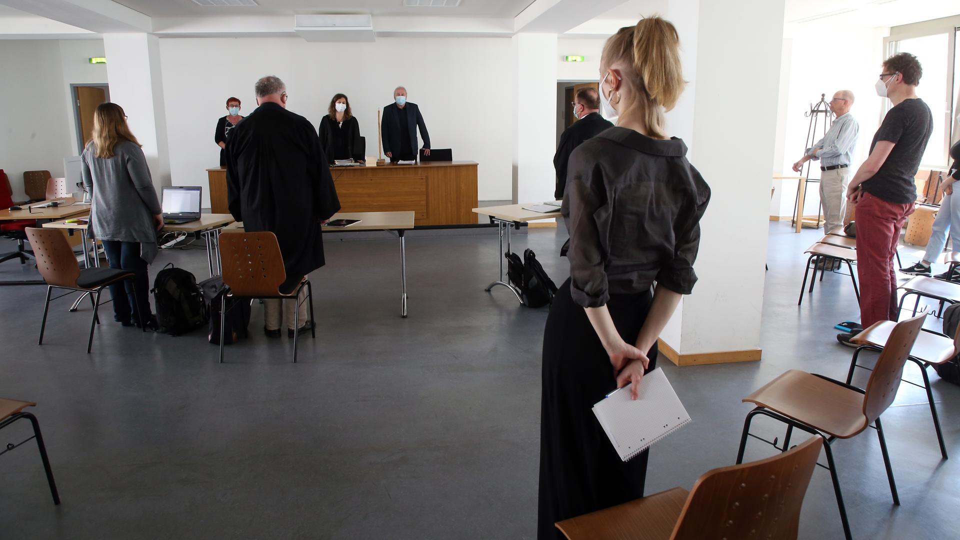 Prozessbeteiligte stehen vor Beginn einer Verhandlung im Gerichtssaal: Ein vom Land Brandenburg gekündigter Lehrer hat gegen seinen Rauswurf geklagt. Das Land wirft ihm vor, rechtsextreme Tätowierungen zu tragen und diese während eines Schulfestes seinen Schülern gezeigt zu haben. Prozessbeteiligte stehen vor Beginn einer Verhandlung im Gerichtssaal: Ein vom Land Brandenburg gekündigter Lehrer hat gegen seinen Rauswurf geklagt. Das Land wirft ihm vor, rechtsextreme Tätowierungen zu tragen und diese während eines Schulfestes seinen Schülern gezeigt zu haben.