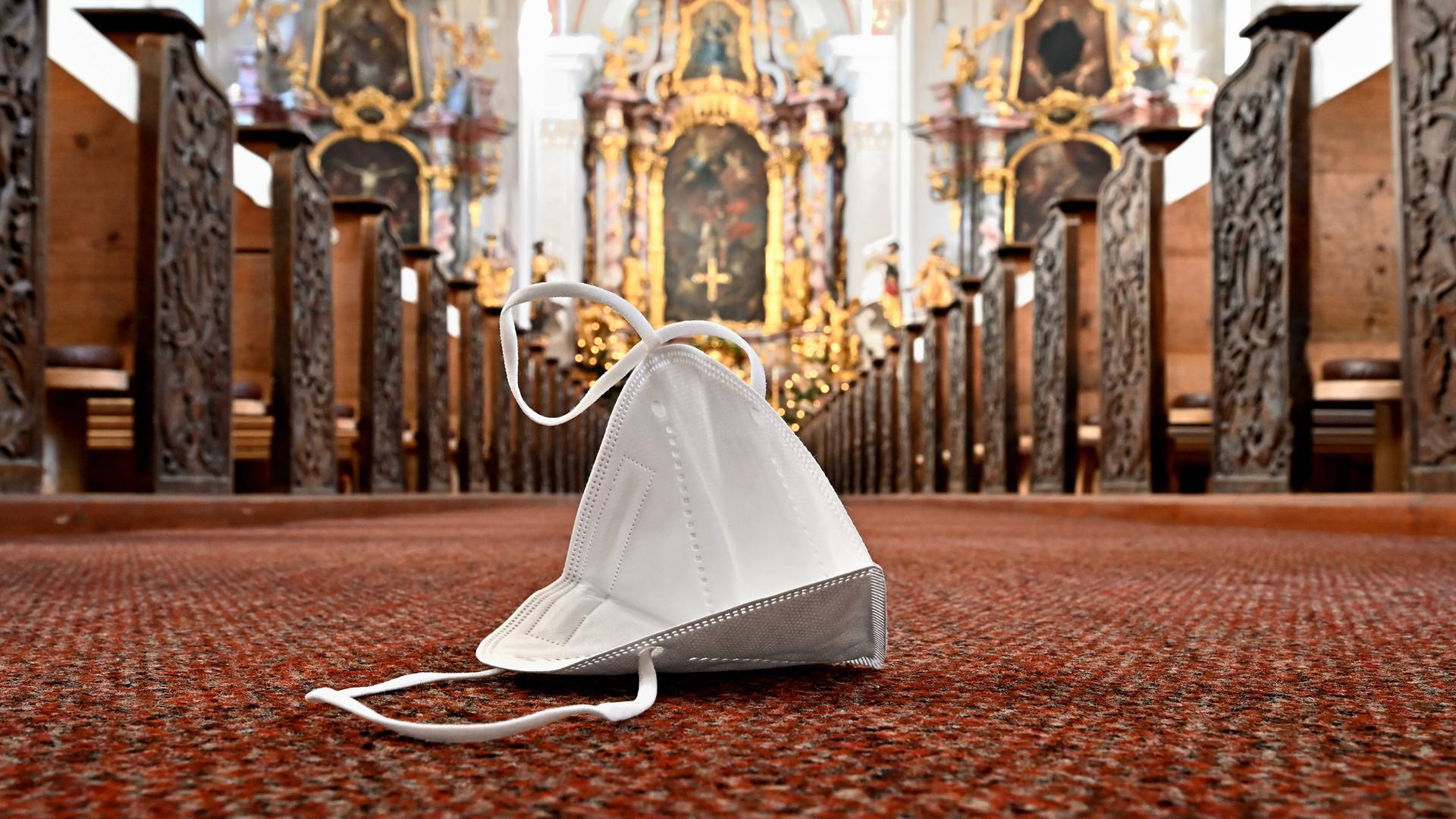 Symbolbild zum Kirchenbesuch während der Coronapandemie, auf dem Kirchenboden liegt eine FFP2-Maske
Symbolbild zum Kirchenbesuch während der Coronapandemie, auf dem Kirchenboden liegt eine FFP2-Maske