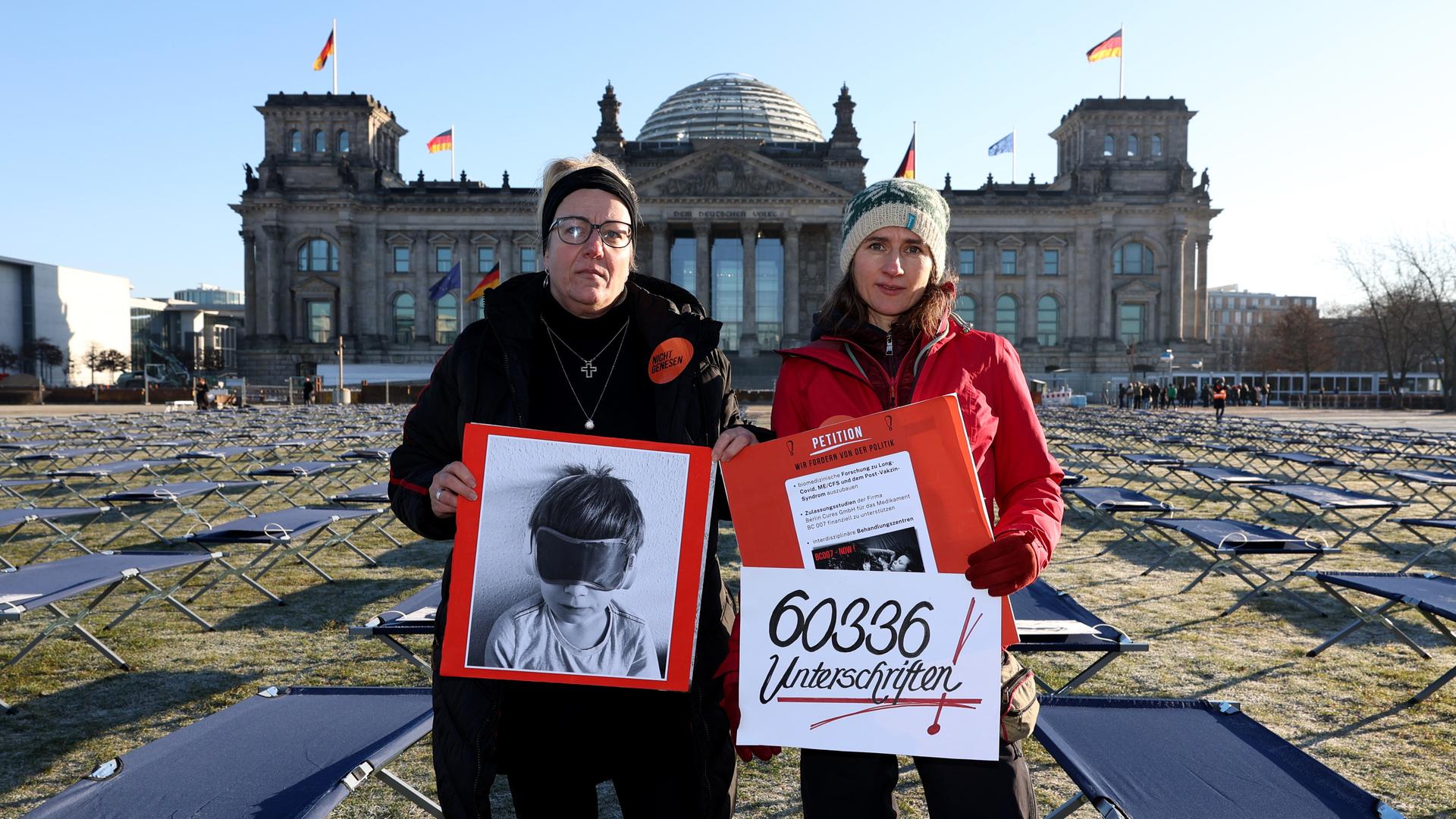 Ricarda Piepenhagen (l) und Elena Lierck demonstrieren stellvertretend für von Post- und Long-Covid-Betroffene vor dem Reichstagsgebäude. 400 Feldbetten mit Porträts der Betroffenen aus ganz Deutschland sind dafür auf der Rasenfläche vor dem Reichstagsgebäude aufgestellt worden. Überreicht werden soll auch eine an die Bundesregierung gerichtete Petition mit gut 60.000 Unterschriften. Ricarda Piepenhagen (l) und Elena Lierck demonstrieren stellvertretend für von Post- und Long-Covid-Betroffene vor dem Reichstagsgebäude. 400 Feldbetten mit Porträts der Betroffenen aus ganz Deutschland sind dafür auf der Rasenfläche vor dem Reichstagsgebäude aufgestellt worden. Überreicht werden soll auch eine an die Bundesregierung gerichtete Petition mit gut 60.000 Unterschriften.