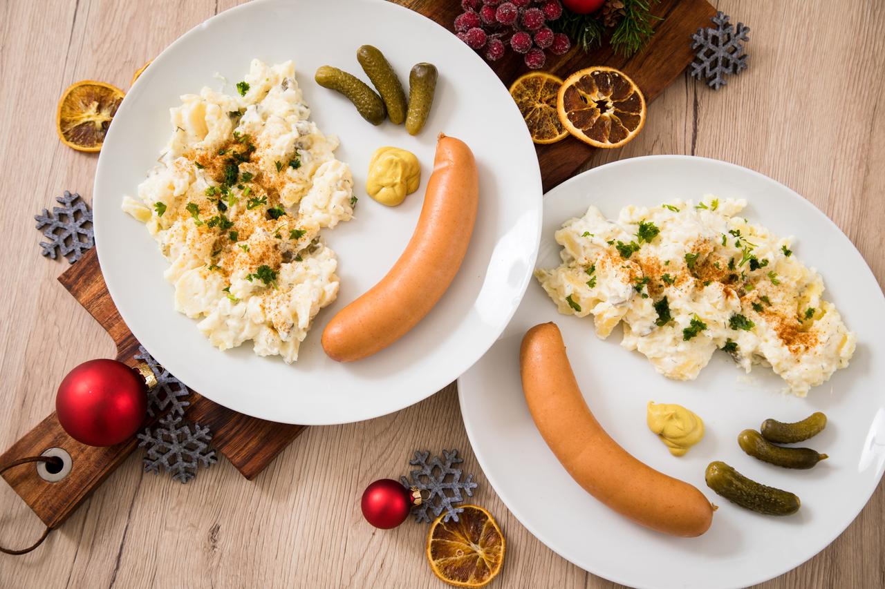 Kartoffelsalat mit Würstchen sind auf Tellern angerichtet (gestellte Szene) Kartoffelsalat mit Würstchen sind auf Tellern angerichtet (gestellte Szene)