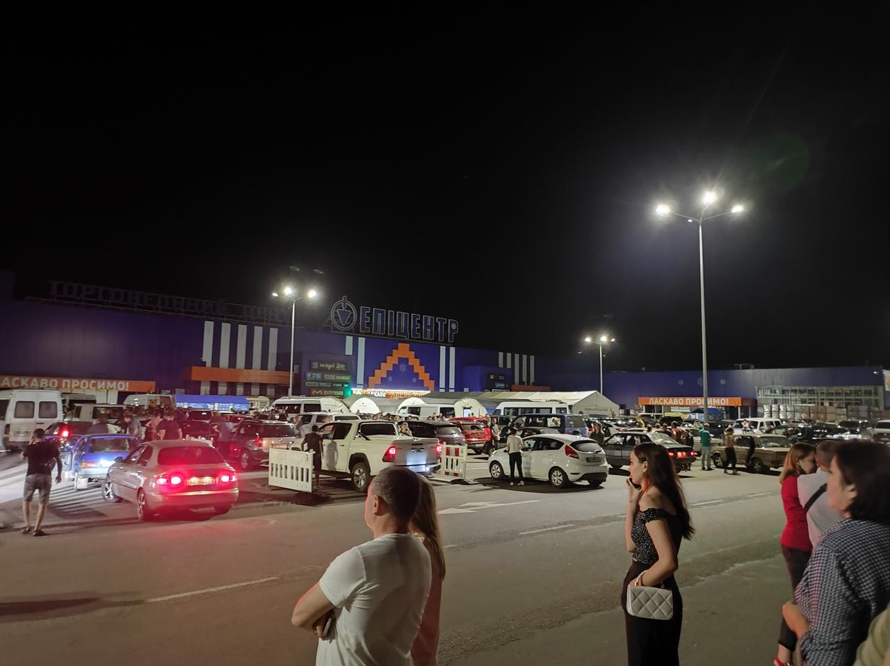 Menschen im Dunkel auf einem Baumarkt-Parkplatz im ukrainischen Saporischschja. Hier warten Menschen auf die Ankunft ihrer Verwandten, die aus den russisch besetzten Gebieten der Ukraine fliehen. Menschen im Dunkel auf einem Baumarkt-Parkplatz im ukrainischen Saporischschja. Hier warten Menschen auf die Ankunft ihrer Verwandten, die aus den russisch besetzten Gebieten der Ukraine fliehen.