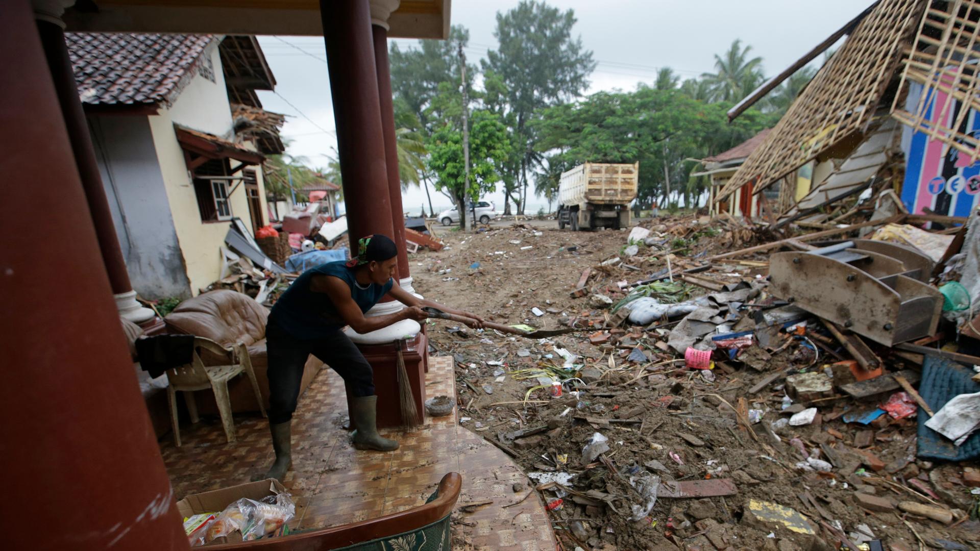 Nach einem Tsunami im Dezember 2018 versucht ein Mann in der indonesischen Region Carita sein Haus und Grundstück aufzuräumen