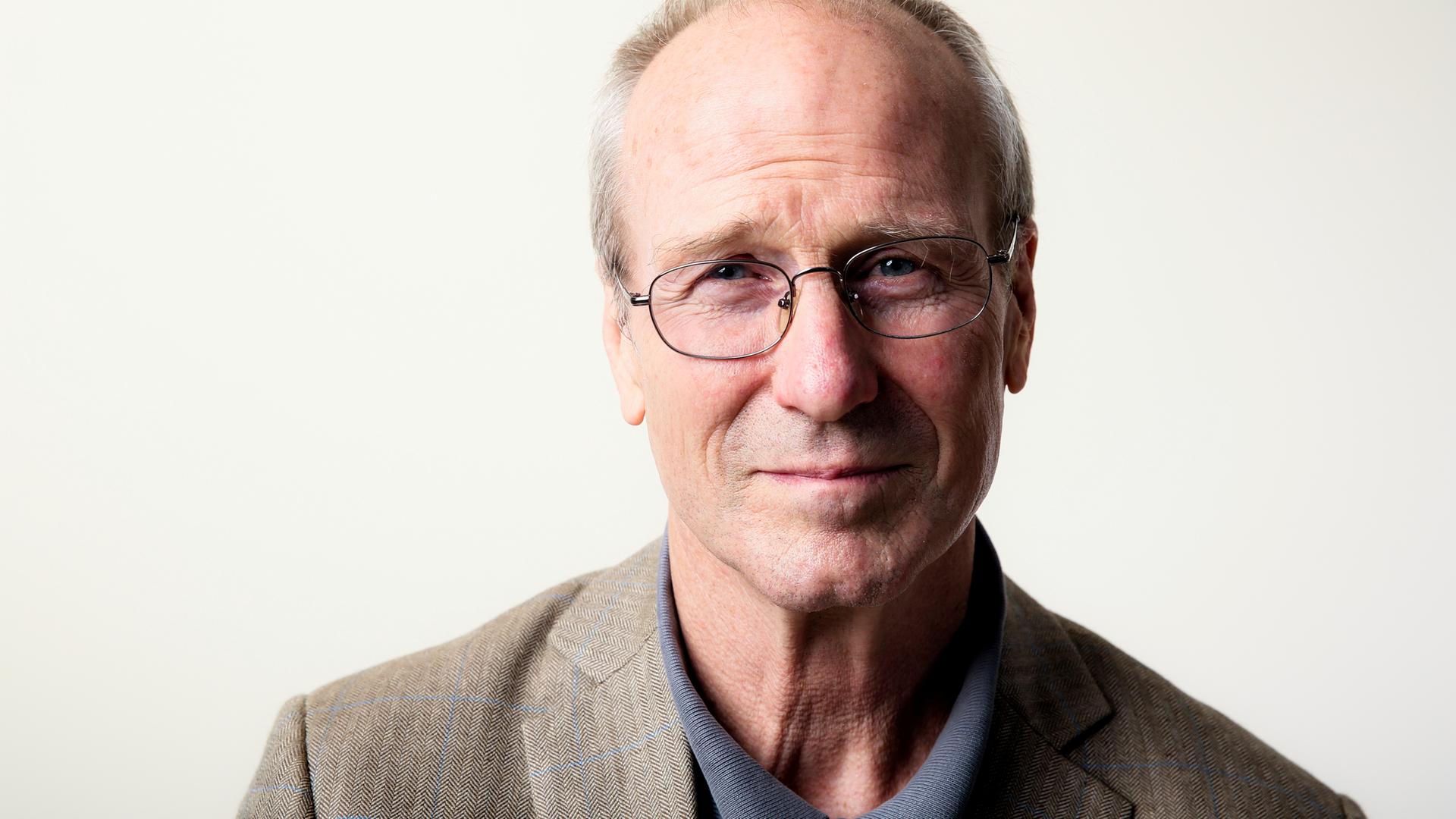 Ein Mann mit Brille schaut freundlich in die Kamera. Ein Mann mit Brille schaut freundlich in die Kamera.