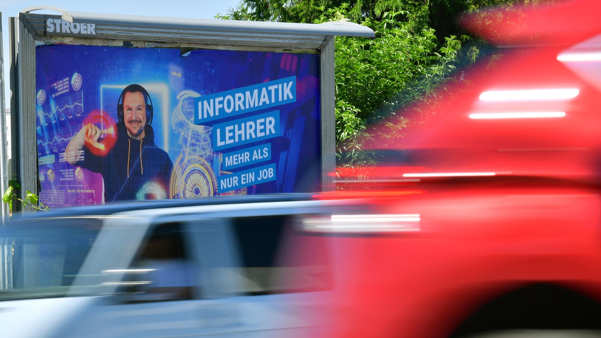 Autos fahren an einem Plakatmotiv der Thüringer Lehrergewinnungskampagne vorbei.