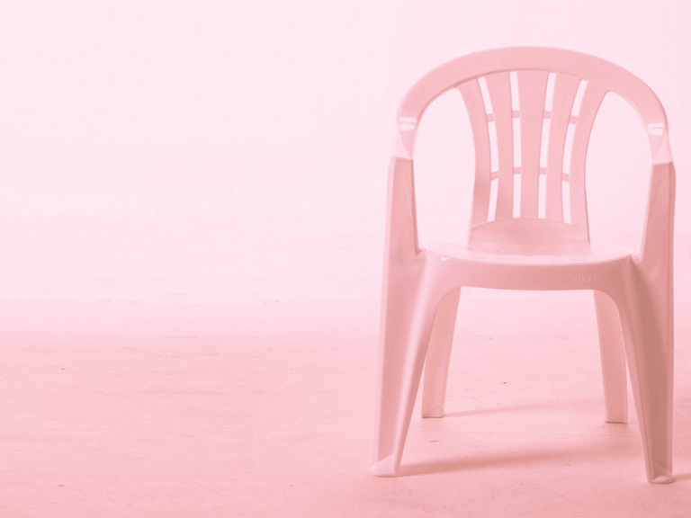 Ein Plastikstuhl mit rosa Hintergrund. 