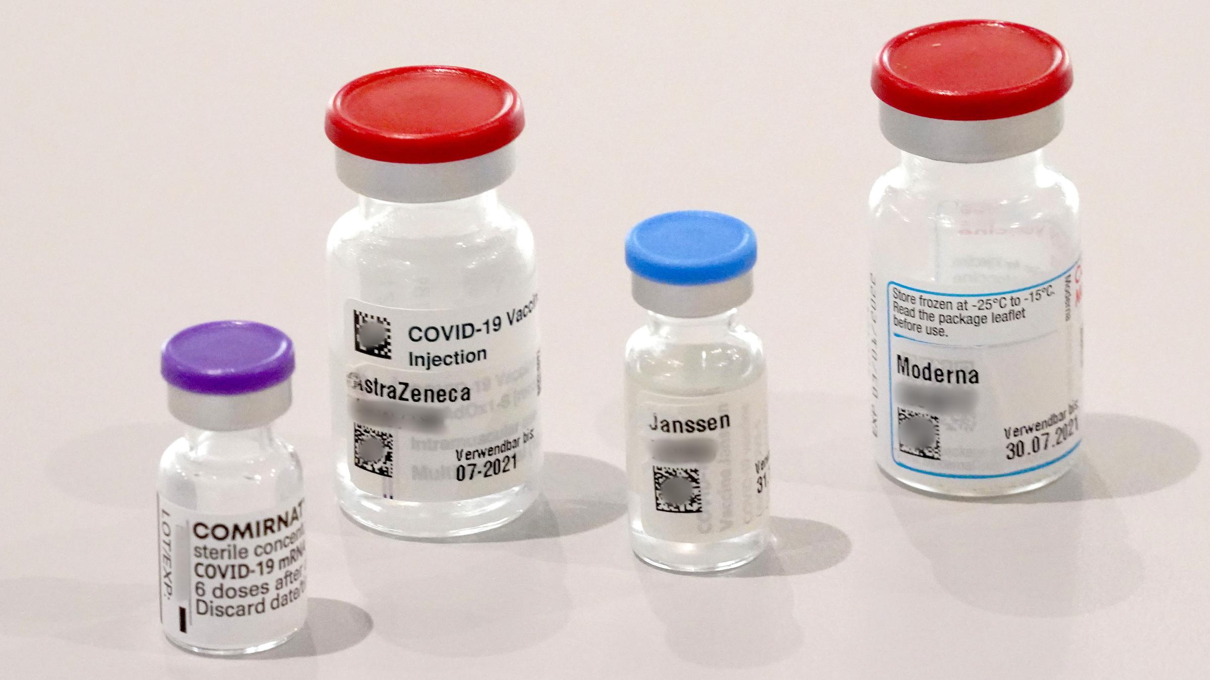 Behälter der Impfstoffe von Biontech, Astrazeneca, Johnson & Johnson und Moderna stehen auf einem Tisch