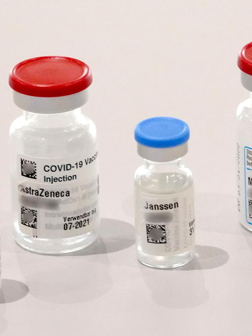 Behälter der Impfstoffe von Biontech, Astrazeneca, Johnson & Johnson und Moderna stehen auf einem Tisch