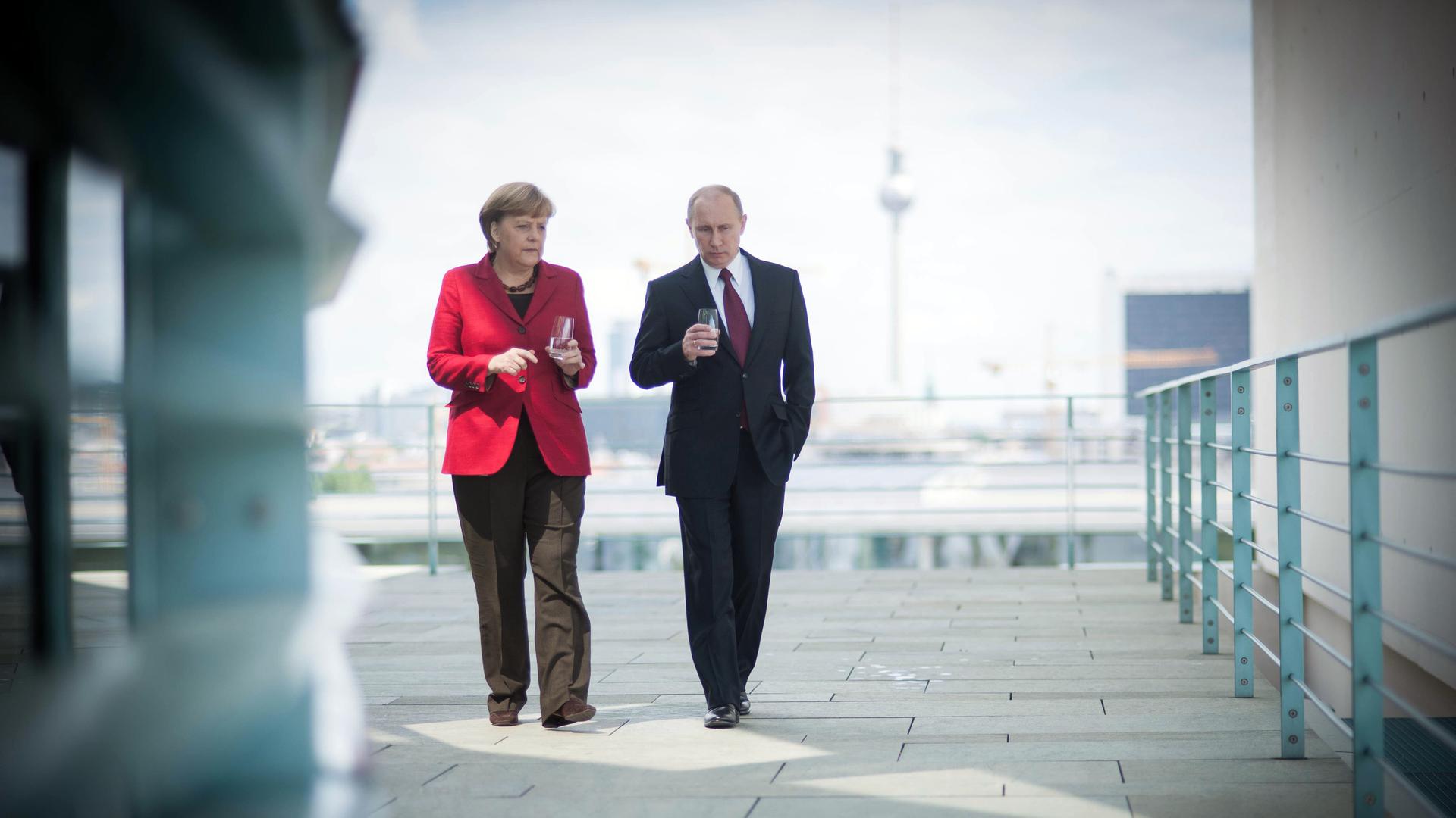 Angela Merkel geht links neben Wladimir Putin. Im Hintergrund der Berliner Fernsehturm.