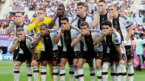 Katar, Al-Rajjan: Die Spieler der deutschen Mannschaft halten sich beim Foto die Hände vor den Mund.