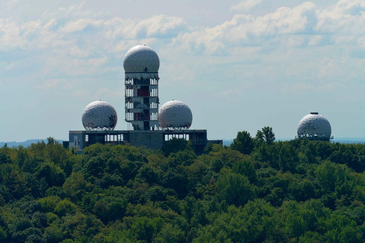 Ehemalige Abhörstation auf dem Berliner Teufelsberg, umgeben von Wald: Kuppeln und ein Turm ragen in die Höhe. Ehemalige Abhörstation auf dem Berliner Teufelsberg, umgeben von Wald: Kuppeln und ein Turm ragen in die Höhe.