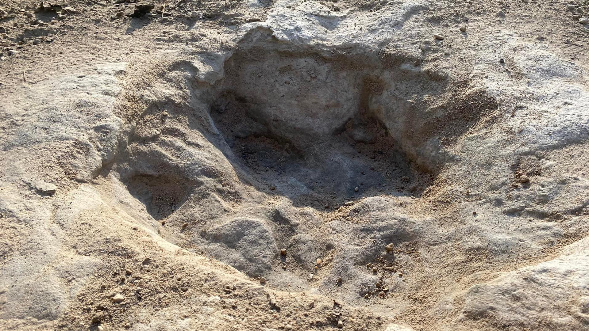 In trockenem Gestein ist ein Abdruck mit drei Zehen zu sehen. In trockenem Gestein ist ein Abdruck mit drei Zehen zu sehen.