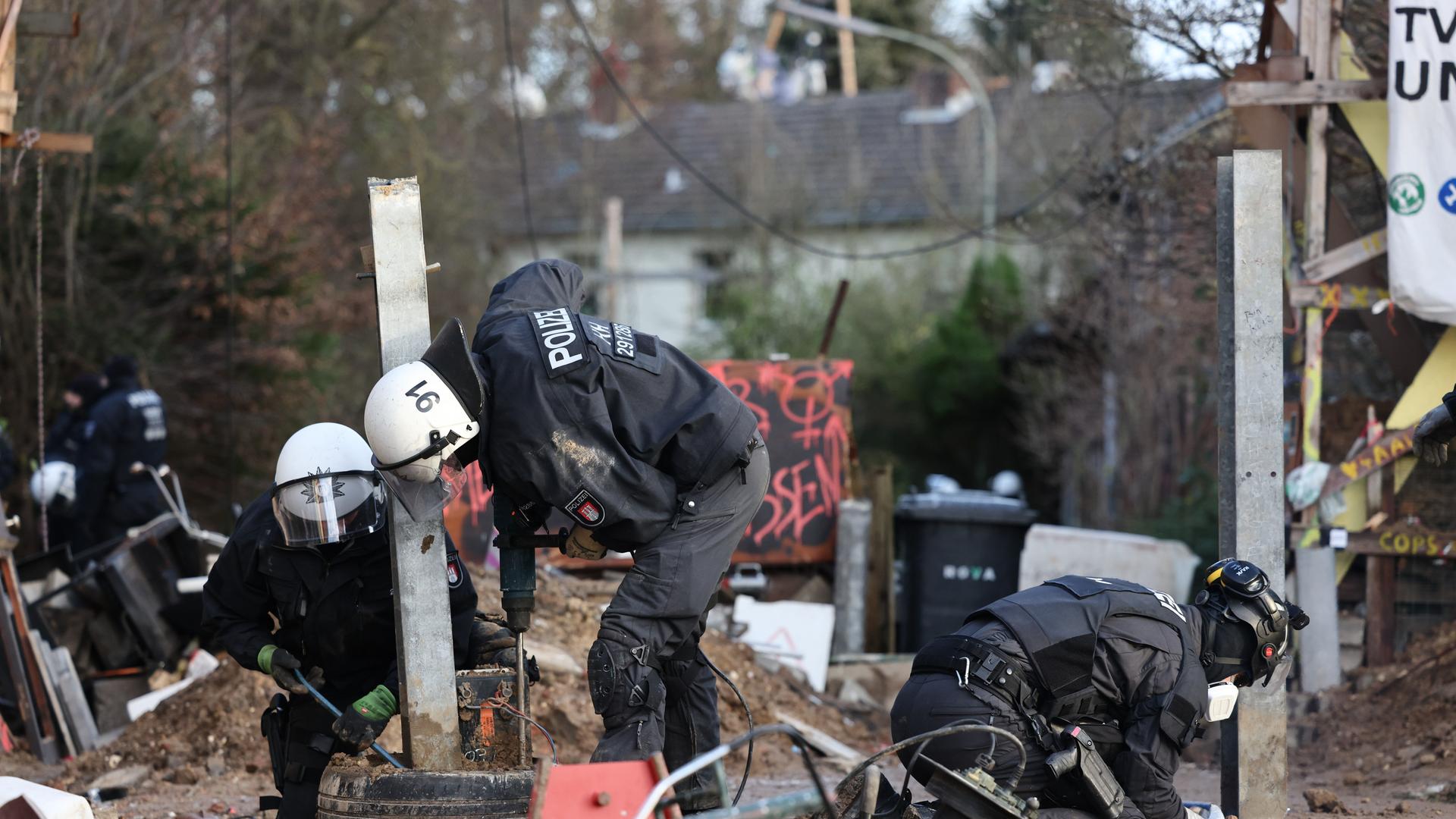 Polizisten entfernen am dritten Tag (13.01.2023) der Räumung des von Klimaaktivisten besetzten Braunkohleorts Lützerath Sperren der Aktivisten