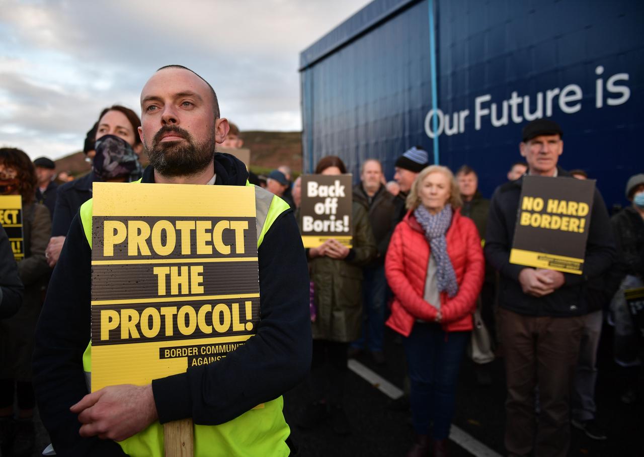Demonstranten protestieren für das Nordirland-Protokoll. Verschiedene Transparente sind zu sehen. Unter anderem ein gelbes Schild auf dem Steht: "Schützt das Protokoll". Demonstranten protestieren für das Nordirland-Protokoll. Verschiedene Transparente sind zu sehen. Unter anderem ein gelbes Schild auf dem Steht: "Schützt das Protokoll".
