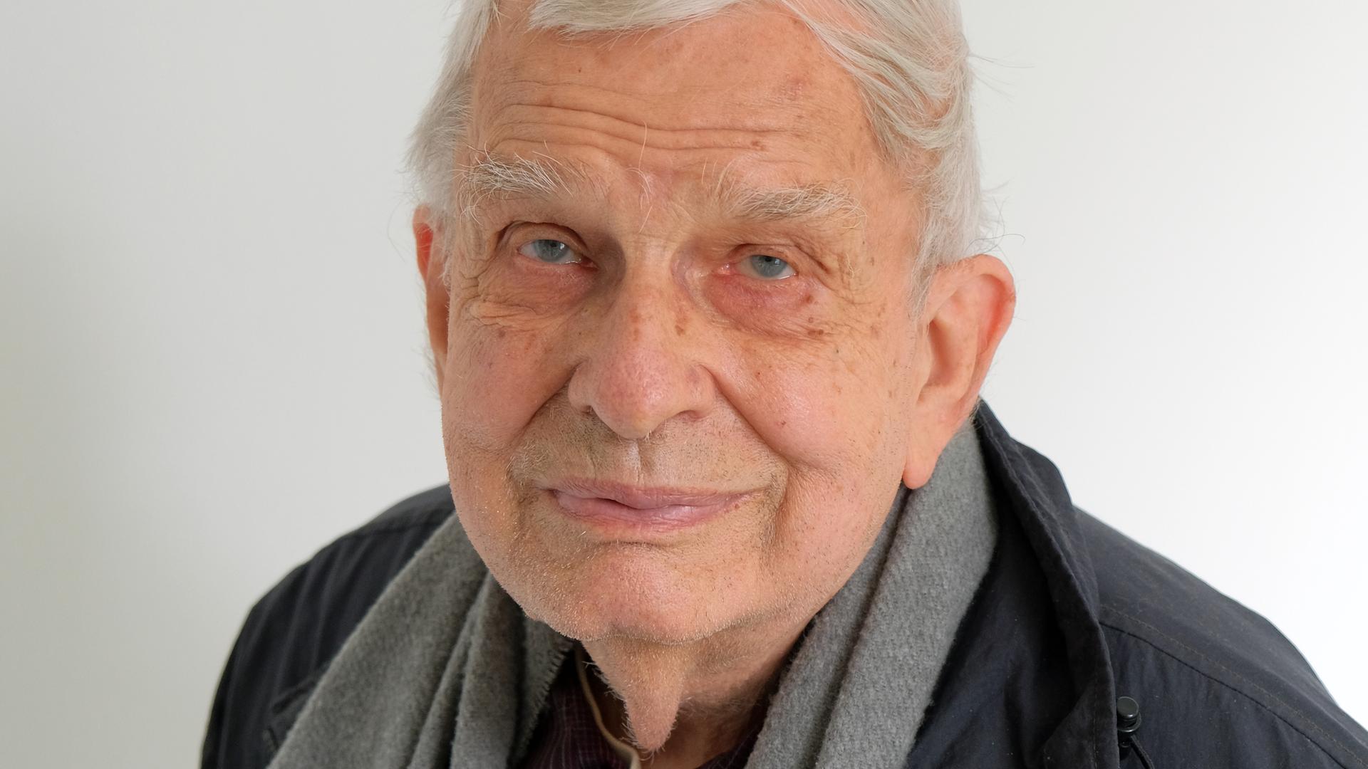 Der 84 Jahre alte Tomas Venclova schaut in die Kamera. Er hat weiße Haare, trägt eine dunkle Jacke und hat ein hellgraues Tuch um den Hals gelegt. Der 84 Jahre alte Tomas Venclova schaut in die Kamera. Er hat weiße Haare, trägt eine dunkle Jacke und hat ein hellgraues Tuch um den Hals gelegt.