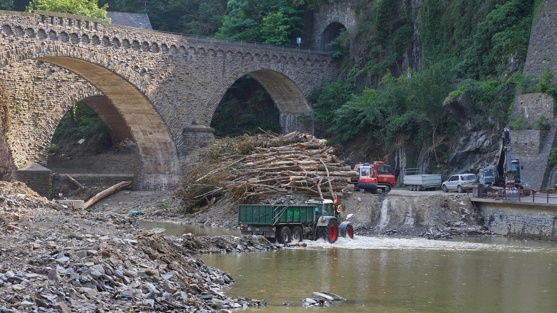 Ein Traktor fährt durch das Ahrtal bei Altenahr, um dort Schutt zu laden, den die Flut hinterlassen hat. Ein Traktor fährt durch das Ahrtal bei Altenahr, um dort Schutt zu laden, den die Flut hinterlassen hat.