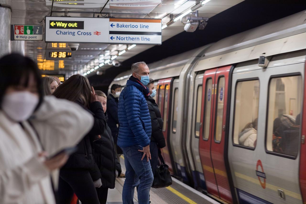 Großbritannien, London: Fahrgäste tragen in einem U-Bahnhof Mund-Nasen-Bedeckung als Präventivmaßnahme gegen die Verbreitung der Omikron-Variante. 
