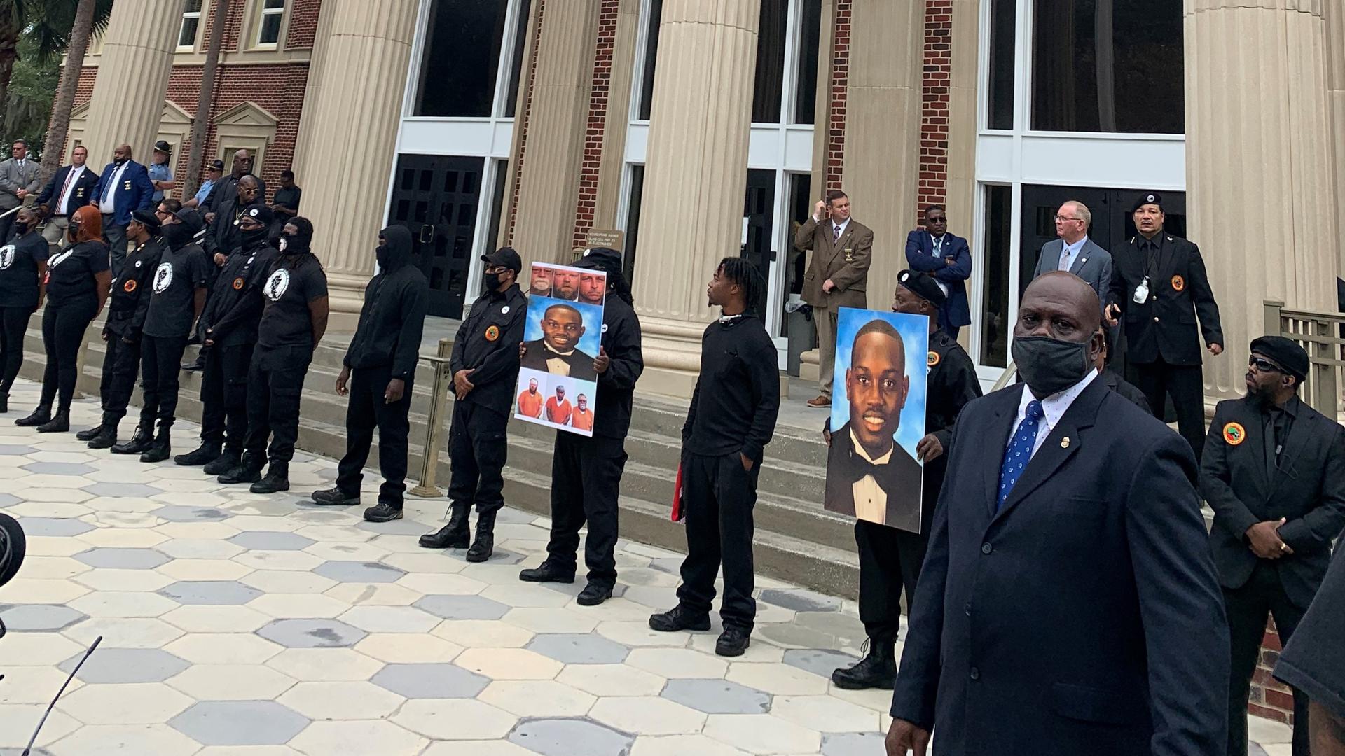 DIe "Black Panther" halten bei einer Demo vor dem Gerichtsgebäude in Georgia Fotos des erschossenen schwarzen Joggers  Ahmaud Arbery 