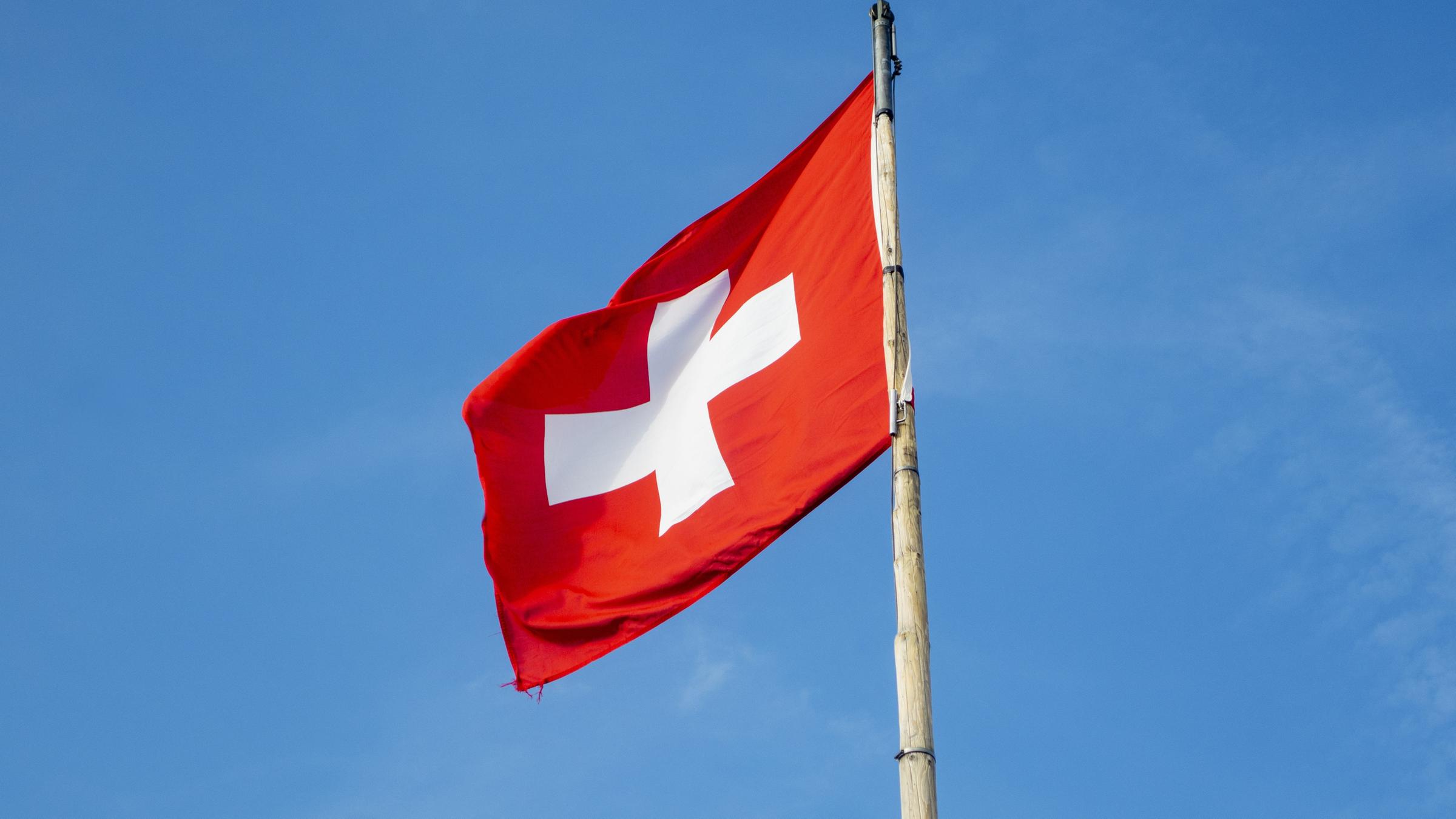 swiss flag, swiss flag on a pole on a sunny day swiss flag, swiss flag on a pole on a sunny day