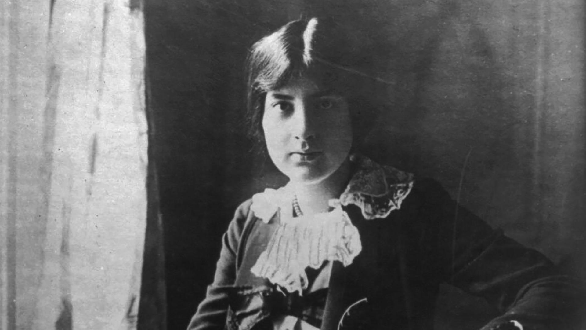 Lili Boulanger sitzt mit ernstem Gesichtsausdruck und hochgesteckten Haaren vor der Kamera. Lili Boulanger sitzt mit ernstem Gesichtsausdruck und hochgesteckten Haaren vor der Kamera.