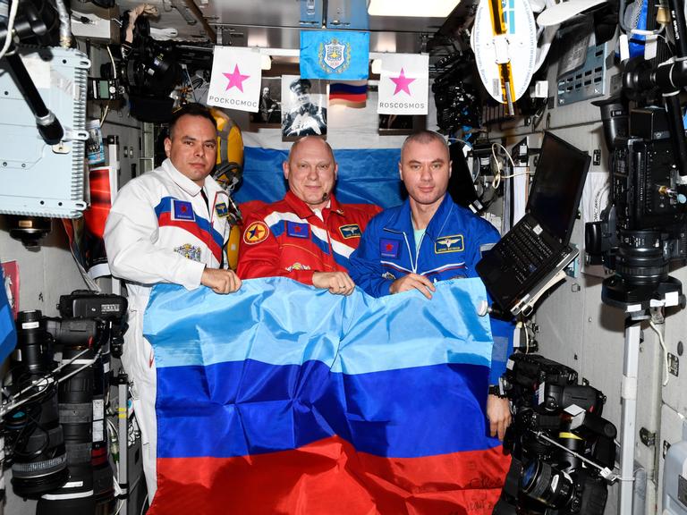 Russische Kosmonauten posieren mit der Flagge der selbsternannten "Volksrepublik" Luhansk an Bord der Internationalen Raumstation