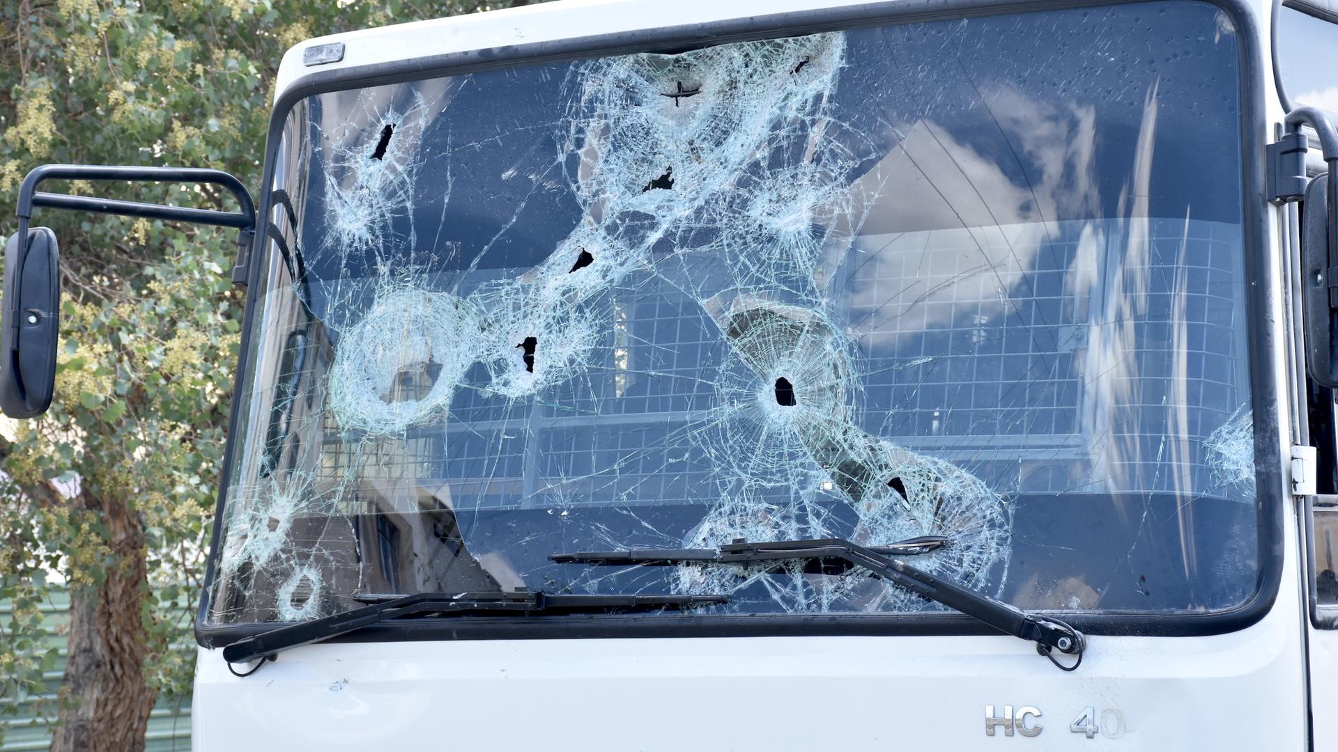 Eine Windschutzscheibe mit Einschusslöchern von einem demolierten Bus nach Protesten in Karakalpakstan's Hauptstadt Nukus, Usbekistan im Juli 2022. Eine Windschutzscheibe mit Einschusslöchern von einem demolierten Bus nach Protesten in Karakalpakstan's Hauptstadt Nukus, Usbekistan im Juli 2022.