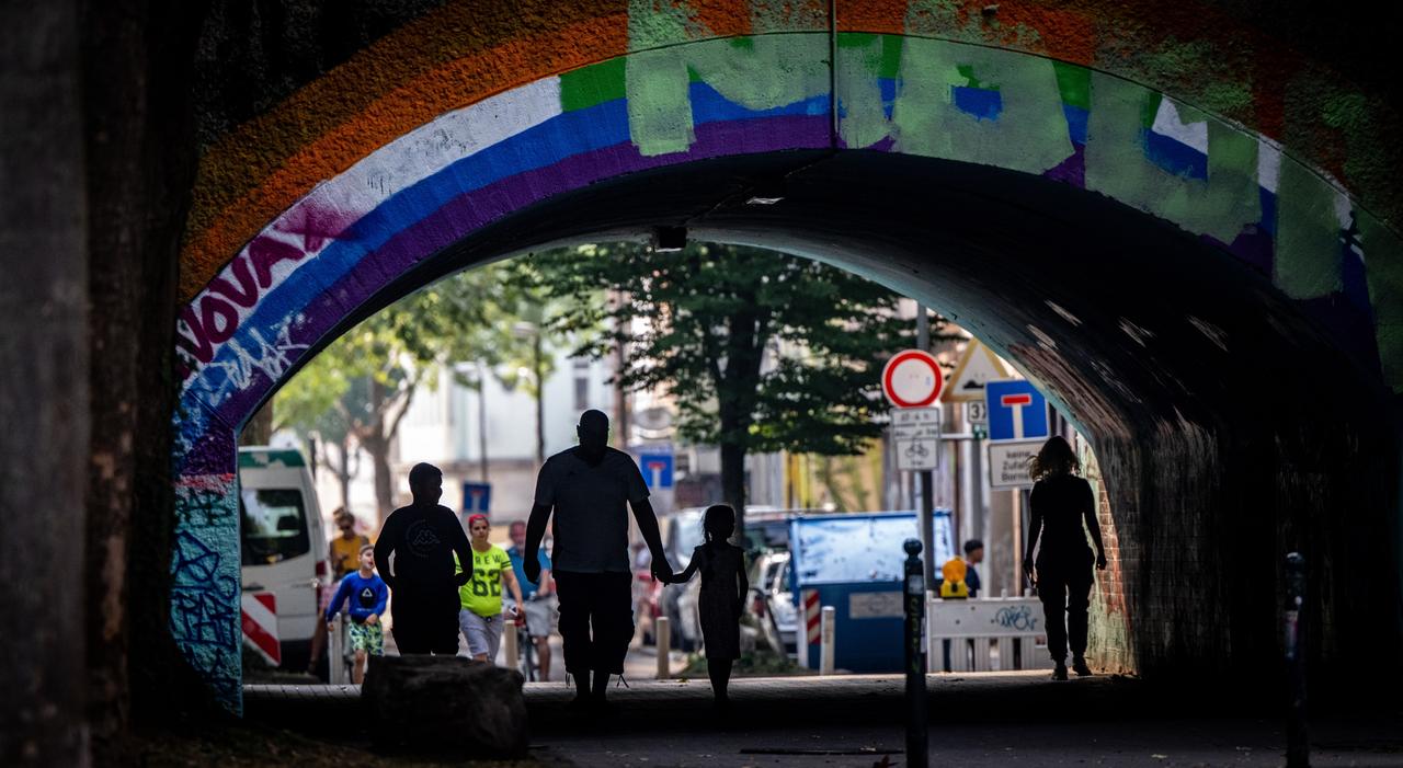 Fußgänger laufen unter einer mit Graffiti besprühten Brücke in der Dortmunder Nordstadt, 17. August 2022. Fußgänger laufen unter einer mit Graffiti besprühten Brücke in der Dortmunder Nordstadt, 17. August 2022.