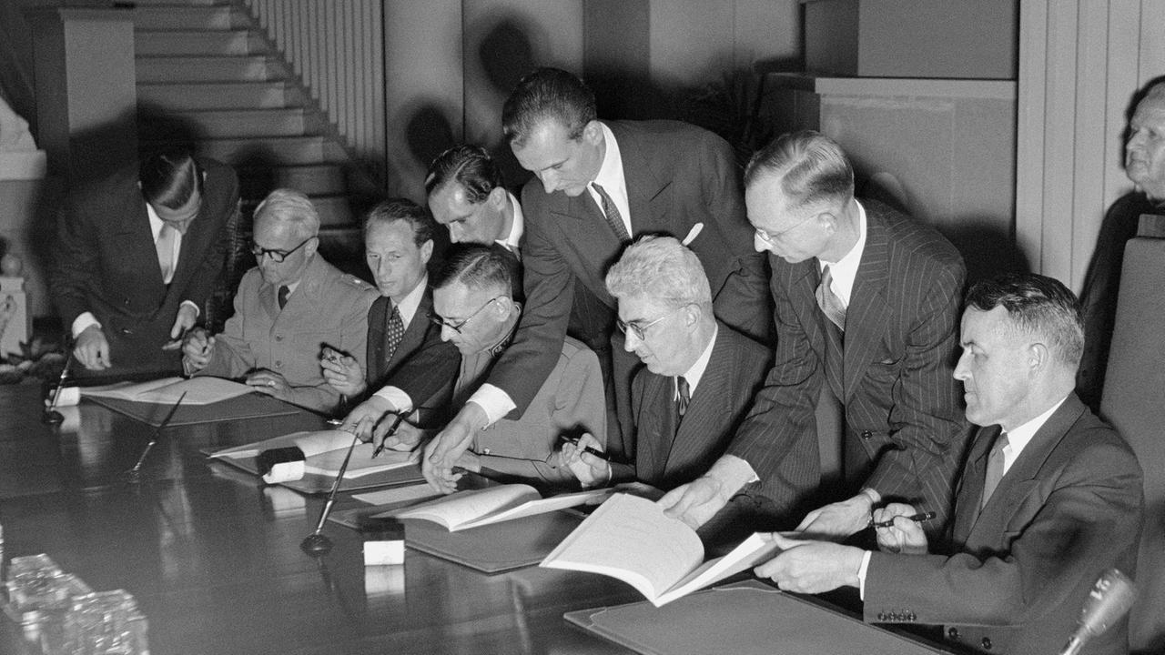 Die Schweizer Delegation unterzeichnet am 12. August 1949 im Palais des Nations in Genf die vier überarbeiteten Genfer Konventionen zum Schutz von Personen, die in einem bewaffneten Konflikt nicht an den Kampfhandlungen teilnehmen Die Schweizer Delegation unterzeichnet am 12. August 1949 im Palais des Nations in Genf die vier überarbeiteten Genfer Konventionen zum Schutz von Personen, die in einem bewaffneten Konflikt nicht an den Kampfhandlungen teilnehmen