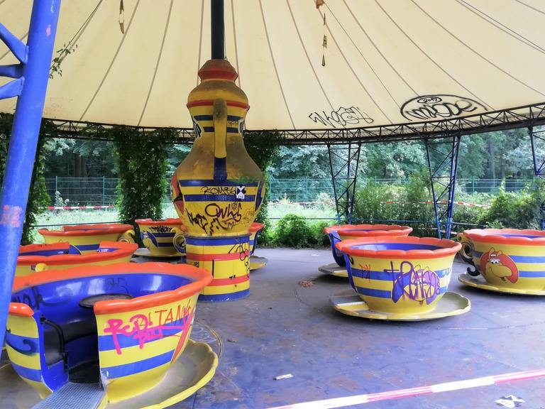 Ein Karussell im Spreepark besteht aus Tassen als Gondeln und einer stilisierten Teekann im Zentrum, um die sich die Tassen drehen. Das Service ist in den Farben Gelb, Rot und Blau gehalten