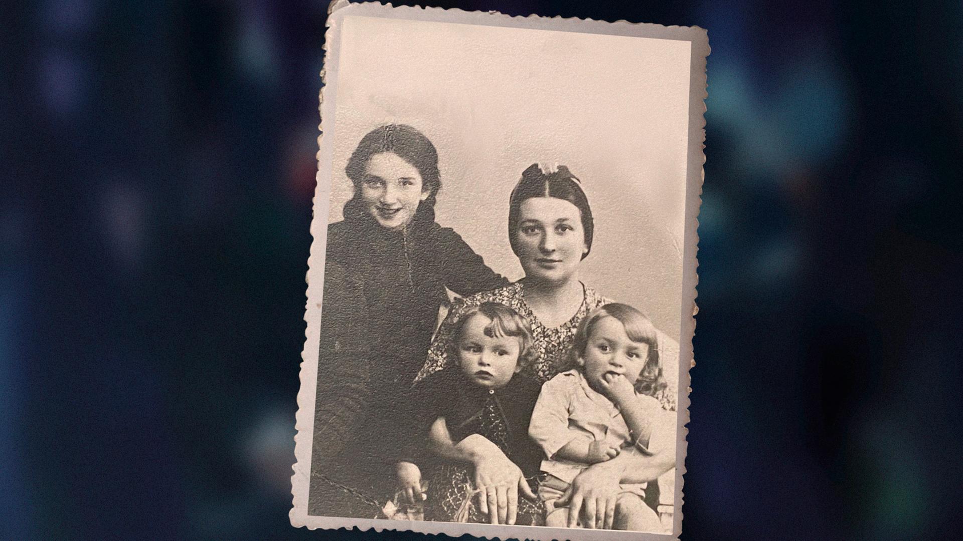 Das Bild zeigt eine alte, schwarzweiße Familienfotografie aus den frühen 1940er . Sie zeigt die dreijährigen Zwillinge Ida und Adam Paluch im Arm ihrer Mutter. Links im Bild ist ihre ältere Schwester Genia zu sehen. Das Bild zeigt eine alte, schwarzweiße Familienfotografie aus den frühen 1940er . Sie zeigt die dreijährigen Zwillinge Ida und Adam Paluch im Arm ihrer Mutter. Links im Bild ist ihre ältere Schwester Genia zu sehen.