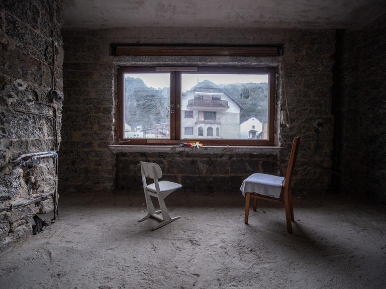Zwei Stühle stehen in einem entkernten Wohnzimmer.