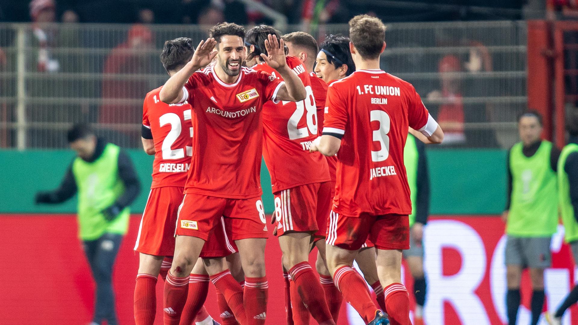 Das Bild zeigt eine jubelnde Traube der Union-Spieler in roten Trikots. Das Bild zeigt eine jubelnde Traube der Union-Spieler in roten Trikots.