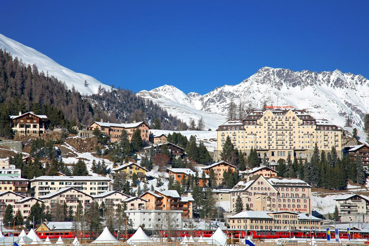 Blauer Himmel und verschneite Berge: Blick auf das winterliche St. Moritz in der Schweiz Blauer Himmel und verschneite Berge: Blick auf das winterliche St. Moritz in der Schweiz