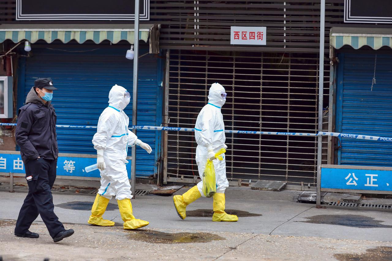 Zwei Männer in Schutzausrüstung suchen Spuren des Virus-Ursprungs auf dem Gelände des Huanan Seafood Market in Wuhan.