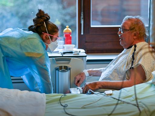 Ein Patient im Gepräch während einer Behandlung im Krankenhauszimmer (Symbolbild)