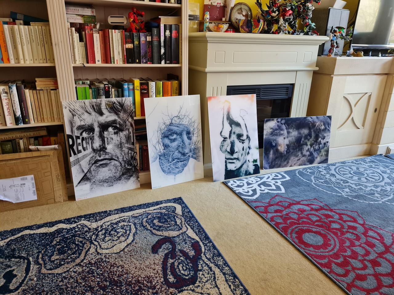 Eine Reihe von Fotos lehnen an einem Bücherregal gelehnt. In dem bunten, mit allerlei Krimskrams zugestellten Raum wirken sie wie Fremdkörper: mysteriös, kühl, irgendwie beunruhigend. Eine Reihe von Fotos lehnen an einem Bücherregal gelehnt. In dem bunten, mit allerlei Krimskrams zugestellten Raum wirken sie wie Fremdkörper: mysteriös, kühl, irgendwie beunruhigend.