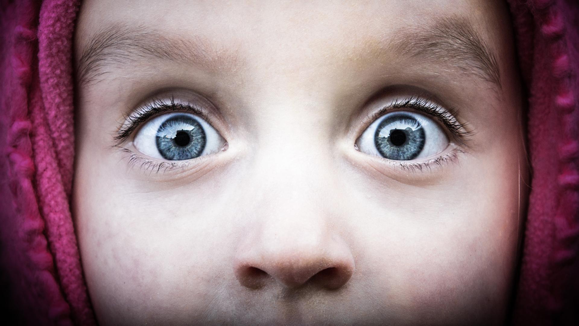 Aufnahme der Augenpartie eines Kindes mit weit aufgerissenen Augen, die grosses Erstaunenausdrücken. Aufnahme der Augenpartie eines Kindes mit weit aufgerissenen Augen, die grosses Erstaunenausdrücken.