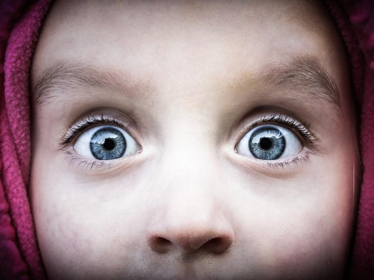 Aufnahme der Augenpartie eines Kindes mit weit aufgerissenen Augen, die grosses Erstaunenausdrücken.