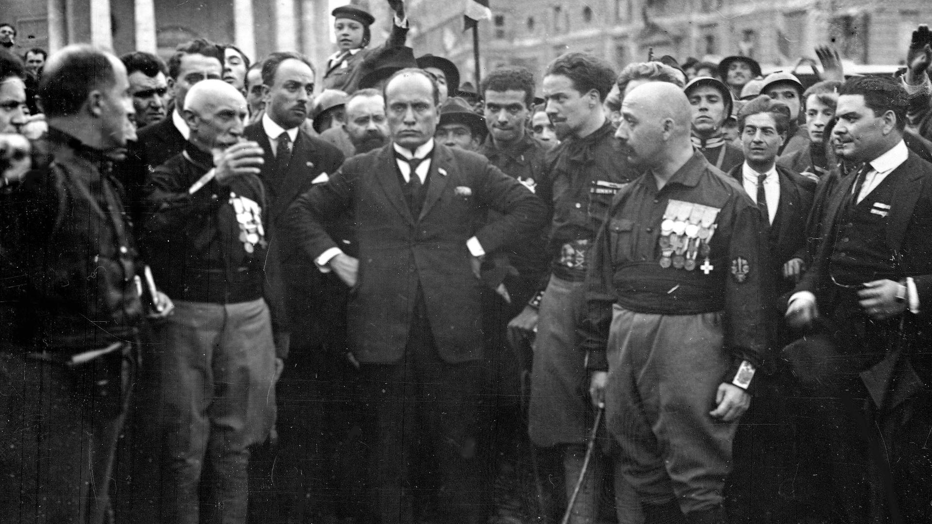 Der Führer der italienischen Faschisten, Benito Mussolini (M), posiert am 29. Oktober 1922 inmitten einiger seiner in schwarze Hemden gekleideter Gefolgsleute. Am Vortag, dem 28. Okotber 1922, waren rund 15000 faschistische "Schwarzhemden", die sich von dem geringen Widerstand der Bevölkerung überrascht zeigten, in Rom einmarschiert. Mit dem "Marsch auf Rom" erzwang Mussolini seine Ernennung zum Ministerpräsidenten. Der Führer der italienischen Faschisten, Benito Mussolini (M), posiert am 29. Oktober 1922 inmitten einiger seiner in schwarze Hemden gekleideter Gefolgsleute. Am Vortag, dem 28. Okotber 1922, waren rund 15000 faschistische "Schwarzhemden", die sich von dem geringen Widerstand der Bevölkerung überrascht zeigten, in Rom einmarschiert. Mit dem "Marsch auf Rom" erzwang Mussolini seine Ernennung zum Ministerpräsidenten.